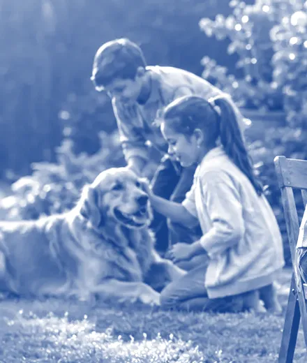 Two children playing with their dog