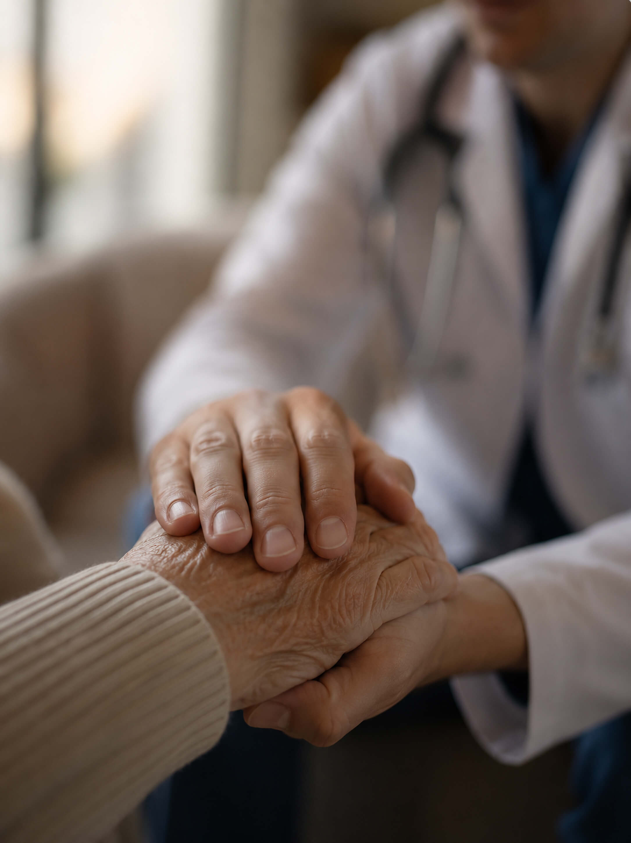 A clinician holding an older patient's hand
